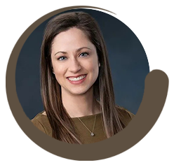 Portrait of Dr. Audrey Dean, M.D., smiling warmly in professional attire against a dark background, representing her role as a dedicated dermatologist – Millcreek Dermatology
